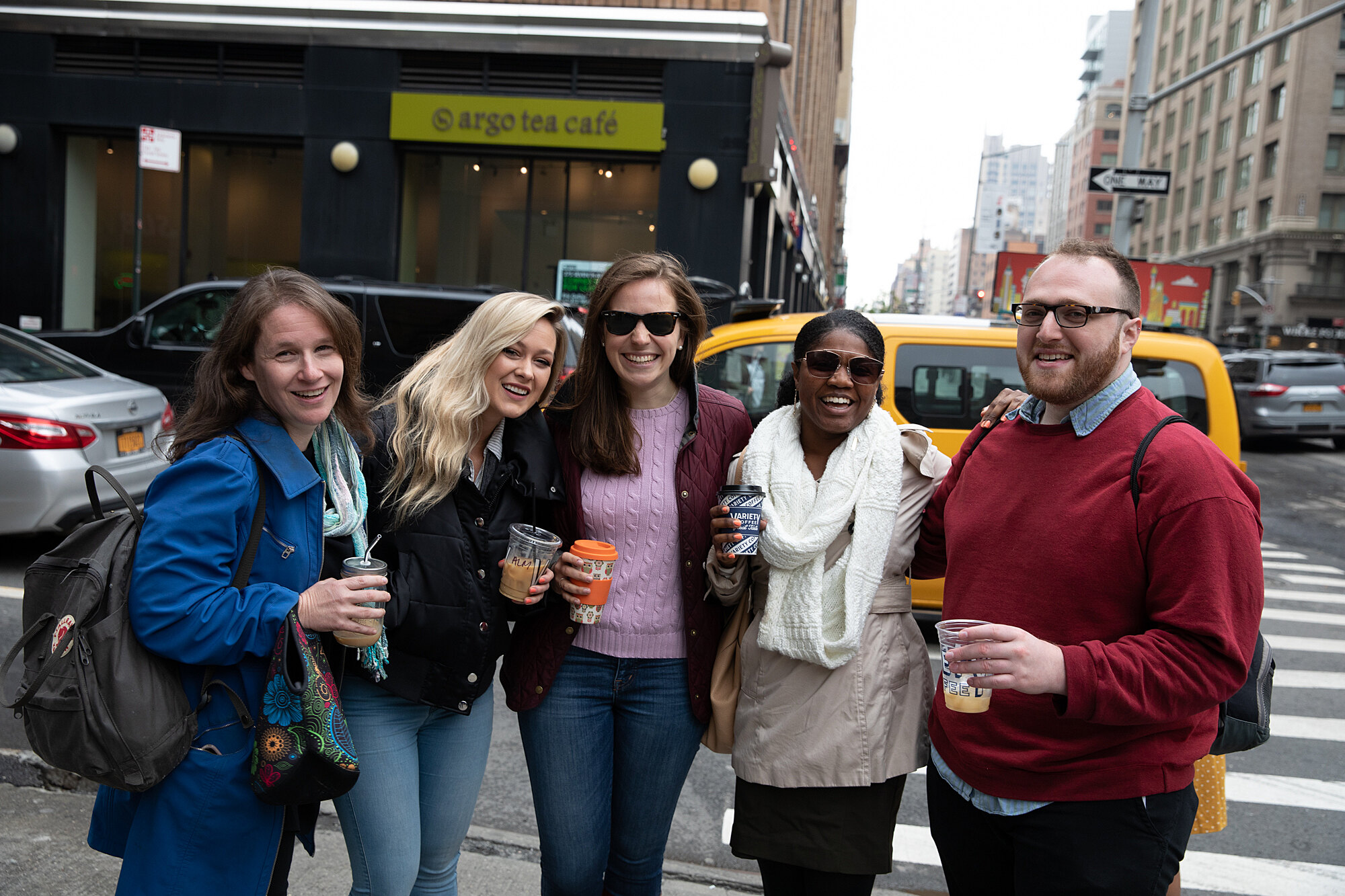 Michelle Kedem, Kristen Poemer, Alana Althans, Imani Doyle, and Sivan Philo pose for a photo on a busy New York City street after a coffee break
