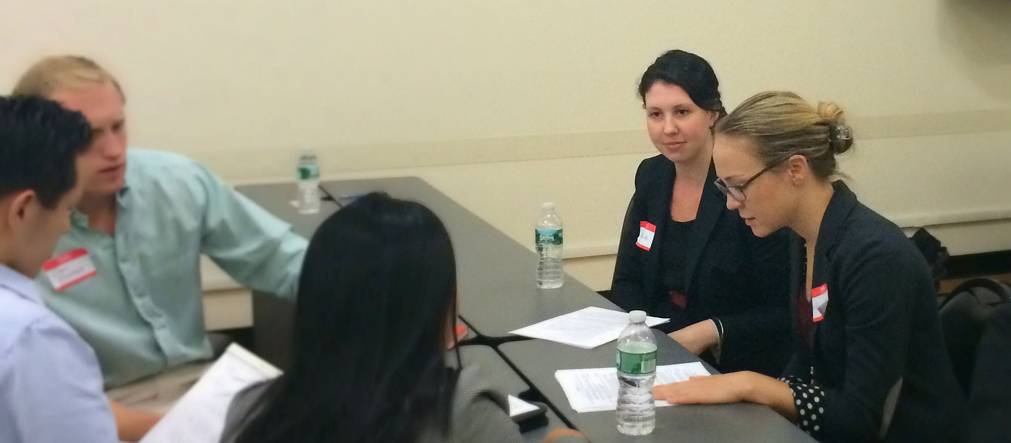 Professional people who attended Net Impact gather at a table to share helpful resources for mission-driven work