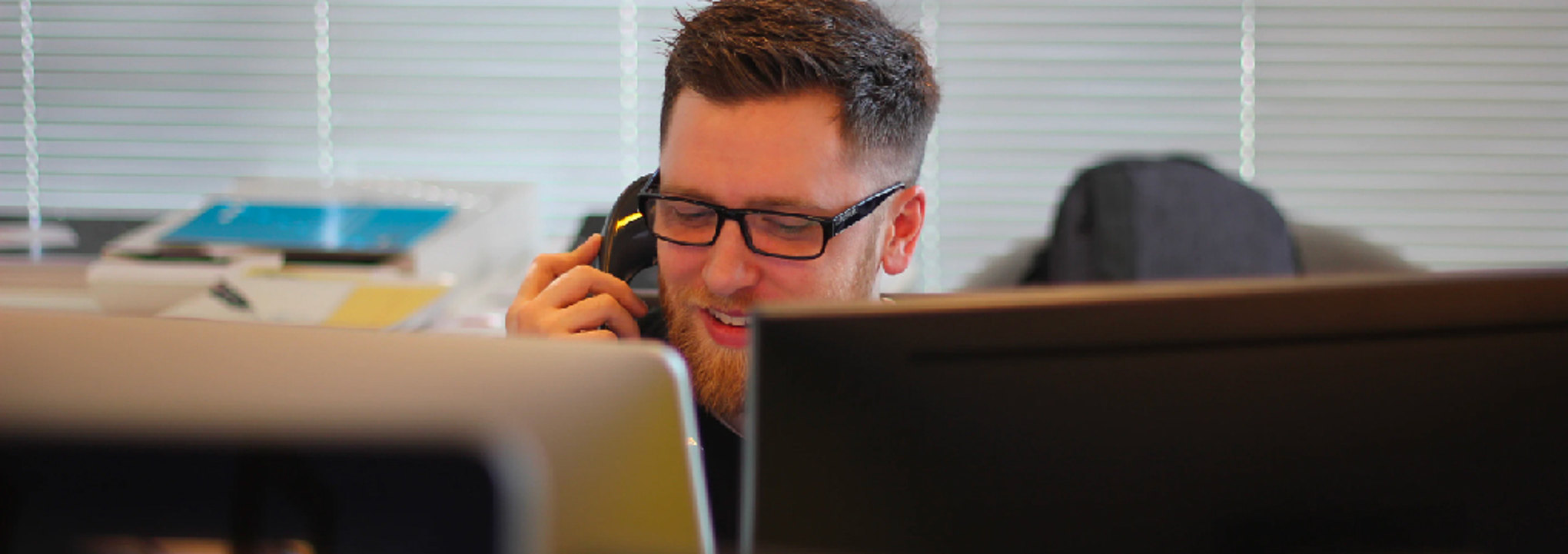 Man talking on the phone while looking at computer