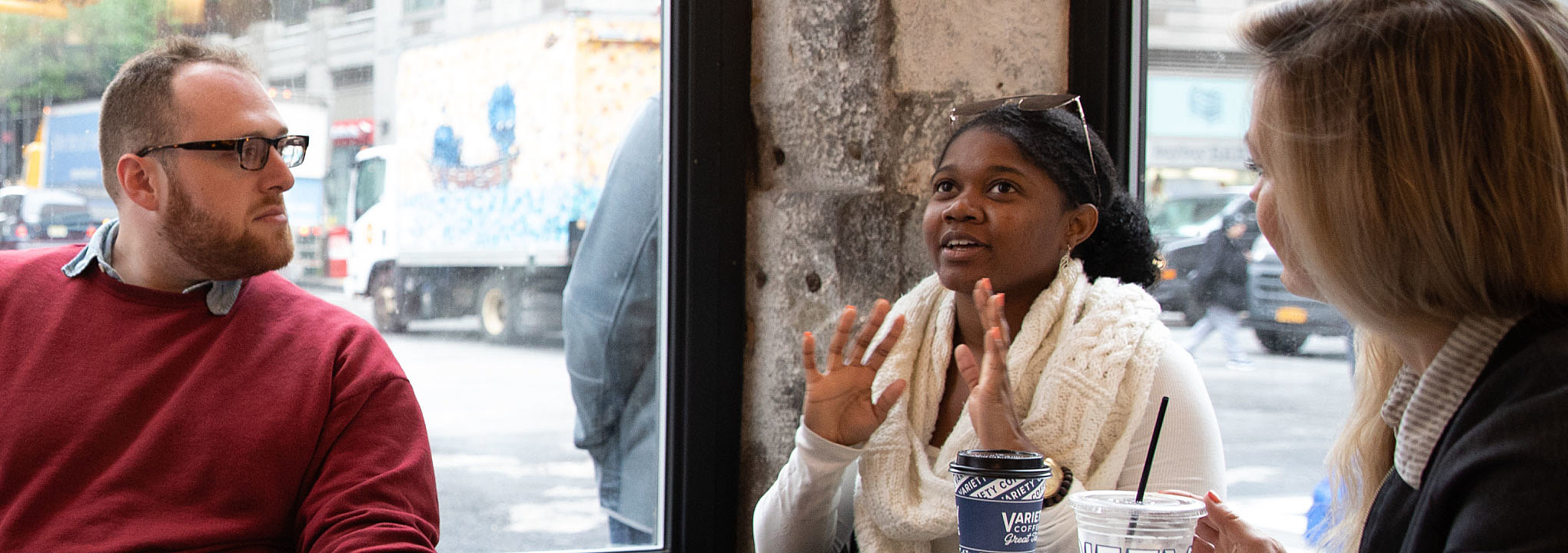 Imani Doyle talks to two On-Ramps coworkers in coffee shop.