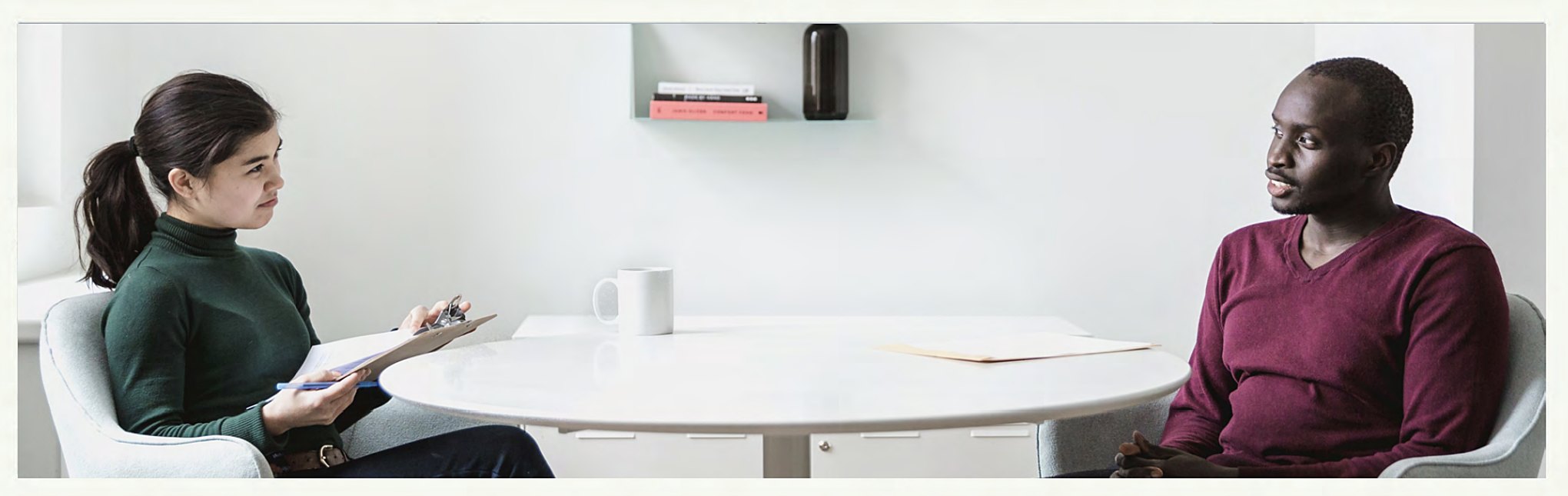 Woman with clipboard considers company core values as she interviews a potential candidate