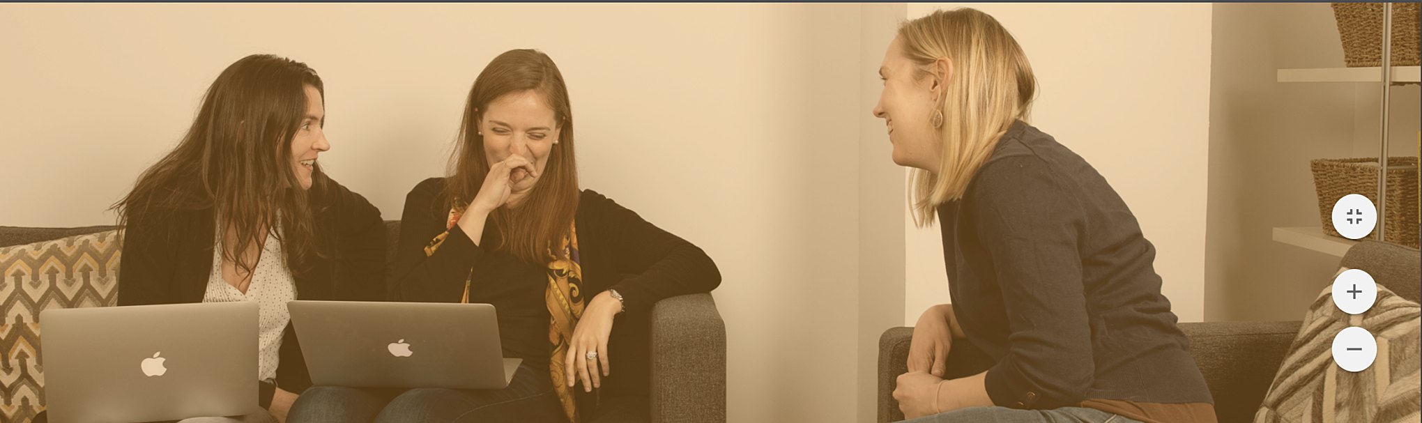 Colleagues enjoy a laugh on the break room sofa